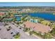 Community clubhouse aerial featuring a pool, tennis courts, parking, and stunning lake views at 10802 Seasons Way, Palmetto, FL 34221