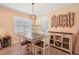 Cozy dining area featuring a modern light fixture, a wine rack, and stylish decor creating an inviting atmosphere at 10802 Seasons Way, Palmetto, FL 34221