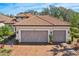 Charming home featuring a well-manicured lawn, a spacious driveway, and a neatly landscaped front yard at 10802 Seasons Way, Palmetto, FL 34221