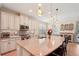 Bright kitchen featuring a spacious island, granite counters, stainless steel appliances, and seamless flow to the dining area at 10802 Seasons Way, Palmetto, FL 34221