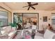 Relaxing covered lanai with comfortable seating, ceiling fan, and a view of the home's interior and backyard at 10802 Seasons Way, Palmetto, FL 34221