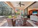 Inviting covered lanai with comfortable seating, ceiling fan, and a view of the backyard's lush greenery at 10802 Seasons Way, Palmetto, FL 34221