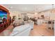 Open-concept living room with hardwood floors, white kitchen cabinets, and an island with barstool seating at 10802 Seasons Way, Palmetto, FL 34221