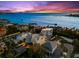 An aerial view of waterfront homes with a colorful sunset at 116 Garden Ln, Sarasota, FL 34242