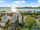 An aerial view showcasing a house on the waterfront with tropical landscaping and city views at 116 Garden Ln, Sarasota, FL 34242