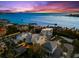 An aerial view of white rooftops with a lovely ocean view and colorful skies at 116 Garden Ln, Sarasota, FL 34242