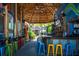 Inviting open-air bar area with colorful stools, thatched roof, and tropical decor in Siesta Key Village at 116 Garden Ln, Sarasota, FL 34242