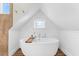 Charming bathroom with a standalone tub and shiplap walls beneath a peaked ceiling window at 116 Garden Ln, Sarasota, FL 34242