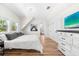 Cozy bedroom with hardwood floors, white walls, a dresser, a TV, and a view of the bathroom at 116 Garden Ln, Sarasota, FL 34242