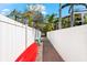Side yard with kayaks, white fence, gravel, and mature tropical landscaping at 116 Garden Ln, Sarasota, FL 34242
