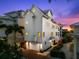 Elegant three-story home featuring a clean white exterior, a two-car garage and a charming entrance at 116 Garden Ln, Sarasota, FL 34242