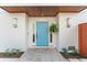 Inviting home entrance with a stylish blue door, modern lighting, and manicured landscaping at 116 Garden Ln, Sarasota, FL 34242