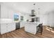 Modern kitchen featuring stainless steel appliances, white cabinets, a center island, and wood-look tile flooring at 116 Garden Ln, Sarasota, FL 34242