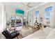 Sunlit living area boasts a coffered ceiling, fan, and sliding doors to an outdoor patio, creating seamless indoor-outdoor living at 116 Garden Ln, Sarasota, FL 34242