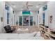Bright living room with high ceilings, a ceiling fan, and large sliding glass doors leading to a deck at 116 Garden Ln, Sarasota, FL 34242