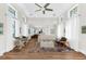 Open-concept living room featuring wood floors, a ceiling fan, and natural light from the many windows at 116 Garden Ln, Sarasota, FL 34242