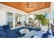 Relax on this covered patio with stylish seating and a ceiling fan, overlooking lush greenery for ultimate comfort at 116 Garden Ln, Sarasota, FL 34242