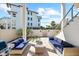 Open-air backyard patio featuring pavers, grill, blue couches, and landscaping at 116 Garden Ln, Sarasota, FL 34242