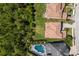 This is a sunny aerial view of several houses featuring an in-ground pool and green foliage at 12022 Medley Ter, Lakewood Ranch, FL 34211