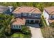 Aerial view of a home with a red tile roof, a paver driveway and lush landscaping at 12022 Medley Ter, Lakewood Ranch, FL 34211