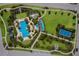 Aerial view of the community pool area with lush landscaping, a splashpad and a nearby tennis court at 12022 Medley Ter, Lakewood Ranch, FL 34211