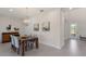 Elegant dining room with modern lighting, a wood table, seating for four, and contemporary art at 12022 Medley Ter, Lakewood Ranch, FL 34211