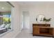 Bright hallway with tile flooring, a decorative table, and a view of the screened-in porch with lounge chairs at 12022 Medley Ter, Lakewood Ranch, FL 34211