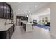 Spacious kitchen with stainless steel appliances, dark cabinets, an island, and an open view to the living room at 12022 Medley Ter, Lakewood Ranch, FL 34211