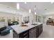 Modern kitchen with stainless steel appliances, sleek island with sink, and pendant lighting at 12022 Medley Ter, Lakewood Ranch, FL 34211