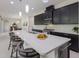 Bright kitchen with stainless steel appliances, dark wood cabinets, and a large island with a waterfall countertop at 12022 Medley Ter, Lakewood Ranch, FL 34211
