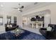 An open-concept living room with ceiling fan and furniture that flows into a kitchen with a breakfast bar at 12022 Medley Ter, Lakewood Ranch, FL 34211