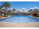 Expansive pool surrounded by a spacious deck, palm trees, and lounge chairs, creating a perfect outdoor retreat at 12022 Medley Ter, Lakewood Ranch, FL 34211