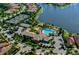 Aerial view of community pool, tennis court, clubhouse, and waterways on a sunny day at 1239 Burgos Dr # 305, Sarasota, FL 34238