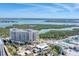 Gorgeous aerial view of a luxurious building near the coast, featuring beautiful vegetation and teal waters at 1300 Benjamin Franklin Dr # 304, Sarasota, FL 34236