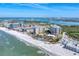 Stunning aerial view showcasing beachfront condos, pristine white sands, and turquoise waters on a sunny day at 1300 Benjamin Franklin Dr # 304, Sarasota, FL 34236