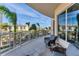 Inviting balcony with comfortable seating and views of the city skyline and palm trees at 1300 Benjamin Franklin Dr # 304, Sarasota, FL 34236