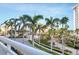 Landscaped exterior view from the balcony showcasing lush greenery and the building's entrance at 1300 Benjamin Franklin Dr # 304, Sarasota, FL 34236