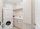 Bright laundry room with a stackable washer/dryer and ample cabinet space at 1300 Benjamin Franklin Dr # 304, Sarasota, FL 34236