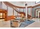 A grand lobby features a two-story staircase, wood-paneled walls, and comfortable seating area on a patterned blue rug at 1300 Benjamin Franklin Dr # 304, Sarasota, FL 34236