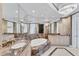 Upscale bathroom featuring a deep soaking tub, dual sinks with marble countertops, designer mirrors, and a luxurious chandelier at 1300 Benjamin Franklin Dr # 304, Sarasota, FL 34236