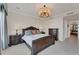 Relax in this luxurious bedroom featuring a chandelier, large windows with a neighborhood view, and dark wood furnishings at 1300 Benjamin Franklin Dr # 304, Sarasota, FL 34236