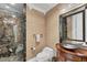 Beautiful powder room with marble shower, decorative mirror, and custom vanity at 1300 Benjamin Franklin Dr # 304, Sarasota, FL 34236
