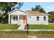 Charming single-story home featuring a bright orange front door, fresh landscaping, and a well-maintained lawn at 1301 12Th S St, St Petersburg, FL 33705