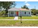 Well-manicured lawn complements this beautifully renovated single-story home with a bright orange front door at 1301 12Th S St, St Petersburg, FL 33705