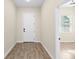 Inviting hallway featuring wood-look tile flooring, a white front door, and an open view to the living area at 1301 12Th S St, St Petersburg, FL 33705