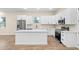 Bright kitchen featuring an island, white cabinets, stainless steel appliances, and modern fixtures at 1301 12Th S St, St Petersburg, FL 33705
