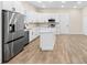 Modern kitchen featuring an island, white cabinets, stainless steel appliances, and wood-look tile flooring at 1301 12Th S St, St Petersburg, FL 33705