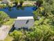 Aerial view of home near a pond with surrounding lush trees at 1471 Arcadia Ave, Sarasota, FL 34232