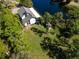 Aerial view of a white home next to a pond with mature trees and a spacious lawn at 1471 Arcadia Ave, Sarasota, FL 34232