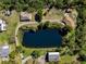 Aerial view of a pond surrounded by houses, outbuildings and lush green trees at 1471 Arcadia Ave, Sarasota, FL 34232